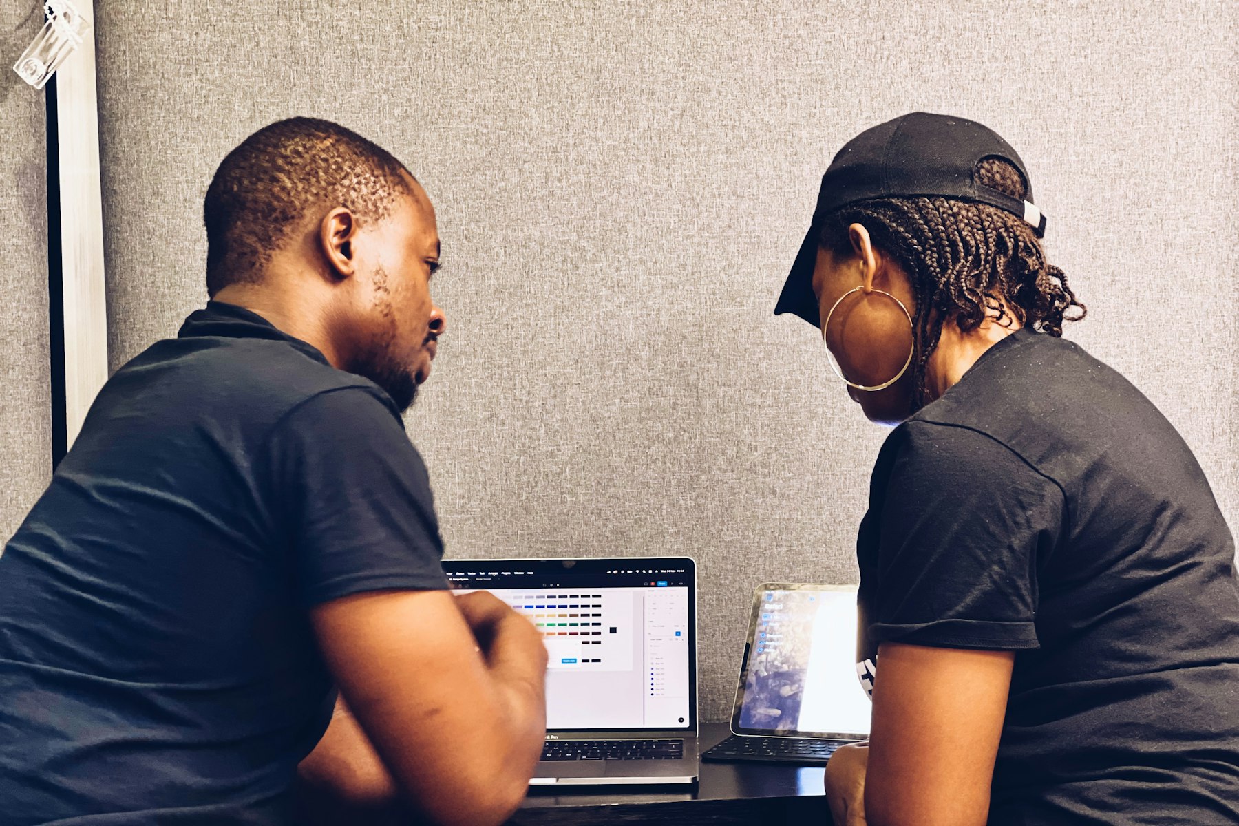 Two engineers working through code together on a laptop